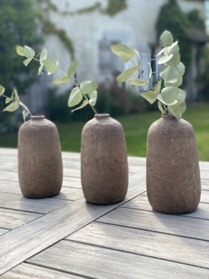 Vase en terracotta mise en situation sur table extérieure avec branches d'eucalyptus